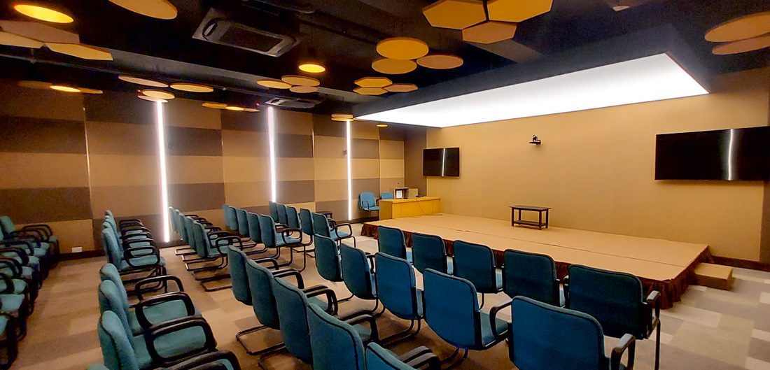 Finished auditorium with acoustic ceiling panels and tiered seating